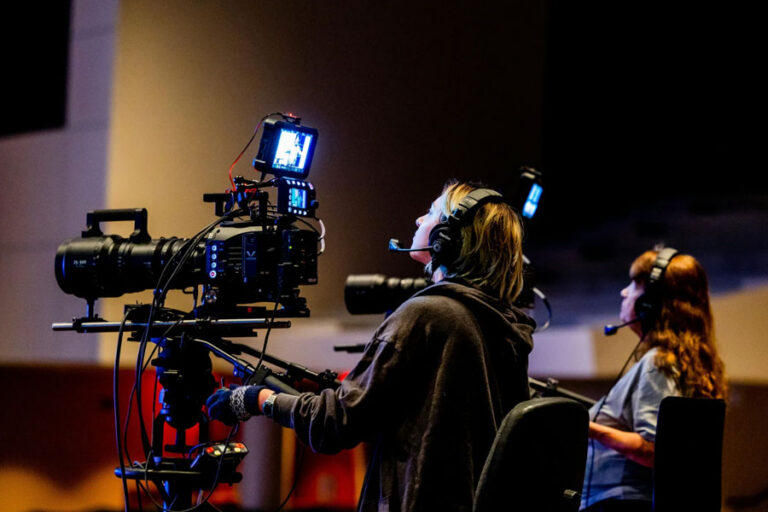 two camera operators framed by light creating a cinematic shot